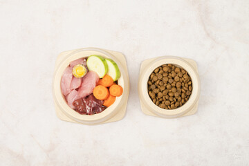 A bowl of dry food and a bowl of natural pet food. Choice of food for dogs and cats. View from above.