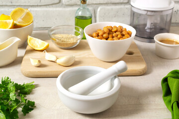 Ingredients for making hummus. Boiled chickpeas, tahini, garlic, lemon and butter. A traditional Middle Eastern dish. Step by step. Horizontal orientation.