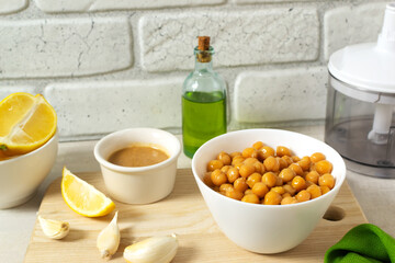 Ingredients for making hummus. Boiled chickpeas and tahini, garlic, lemon and butter. A traditional Middle Eastern dish. Step by step instruction. Horizontal orientation.