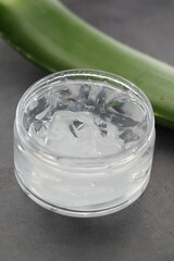 Fresh aloe vera sliced and liquid gel in plastic container on white background 