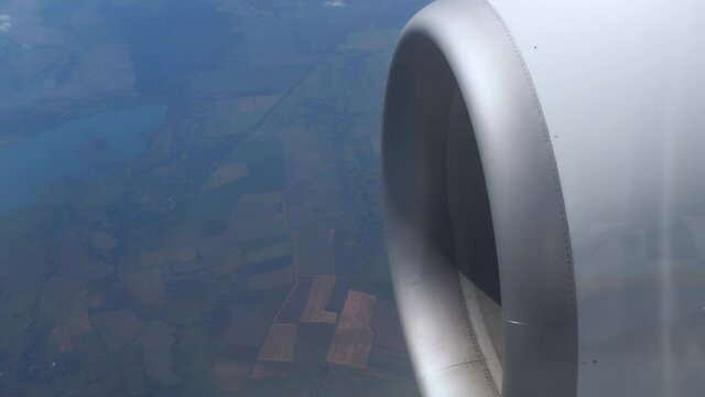 Flying turbine is spinning a motor. Clouds float across sky at high altitude. Flight above ground. View of the turbine of the aircraft and the off on runway. airplane in flight, view from plane window