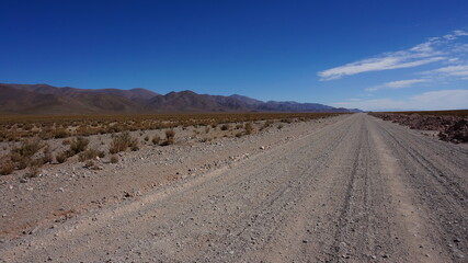 very long straight gravel road in the andes south america