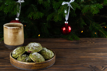 Vegan gingerbread mint with matcha in a bowl on the background of a Christmas tree. Horizontal...