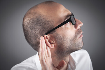 Fototapeta premium Caucasian man hold hand near ear. Trying to hear a gossip