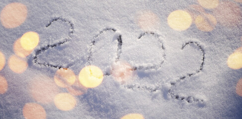 2022 write on snow cover. Happy New Year greeting banner. 