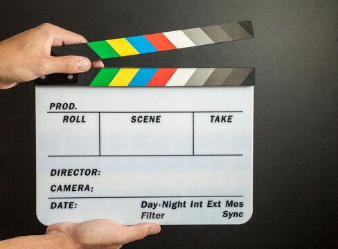 Man holding movie clapper board on black recording studio background. Clapperboard concept. movie concept.
