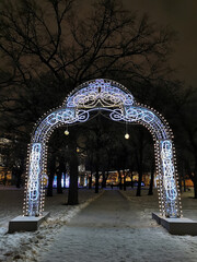 Festive illumination in the form of an arch for Christmas and New Year in the Garden of the Winter Palace of St. Petersburg