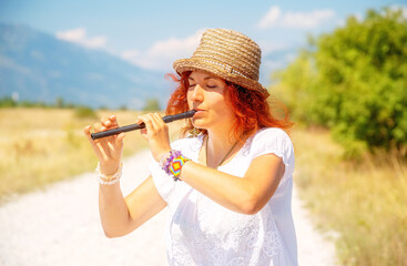 woman with a flute standing on the road.