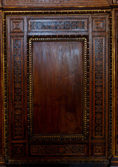 Traditional wood carving on brown wood.