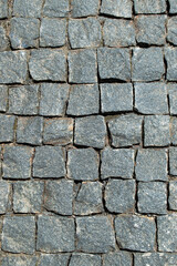 An old stone pavement. The old road. Stone masonry. Gray granite. Square cut stone masonry. Roads of the old city.