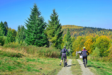 Fototapeta na wymiar Couple bikers ride on the mountains path in autumn sunny day. Natural Light.