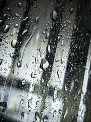 Raindrops running down the window at night.