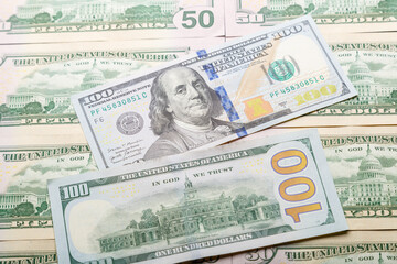 Fifty dollar bills are spread out on the table surface.