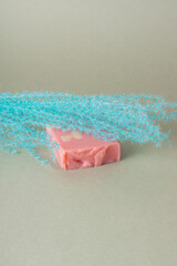 Natural soap for women. Pink soap and blue dried flowers on green background. Space for text
