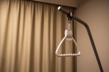 Hospital bed pull-up device. room with brown curtains