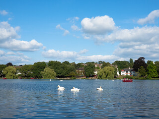 The view of Roath Park in Cardiff with some of clouds on the sky and the green hill with trees