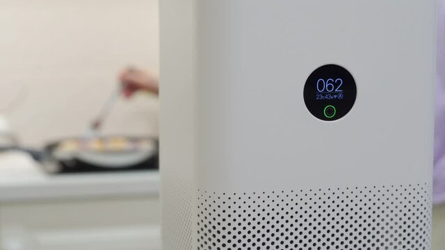 White smart air purifier with digital display showing humidity, temperature and degree of air pollution. Capture and eliminate smoke, dust, pollen at home. High quality 4k footage