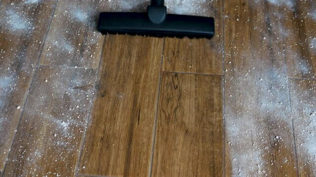 Remove a very dirty floor, vacuum the scattered powder mixture. The man is vacuuming the tiles on the floor