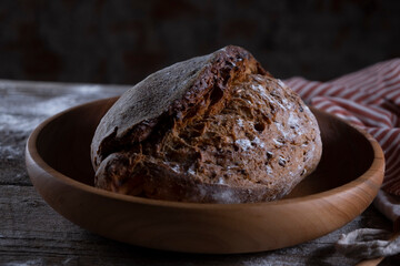 Fresh black bread on a wooden background close-up. Low key still life concept of traditional bakery. rustic