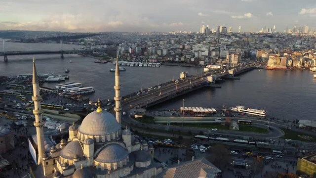 Aerial view of Galata bridge and Halic metro bridge, left, located in the Golden horn waterway, city of Istanbul, Turkey, during sunset. The New Mosque is seen in the bottom.