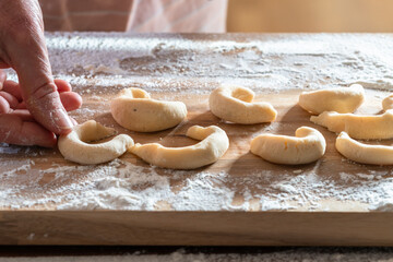 Making kipferl cookies on wooden board in kitchen