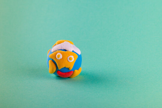 Kids clay creature. Small ball like glode on blue background