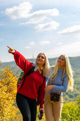 Two beautiful blonde woman walking in the mountain during a sunny day