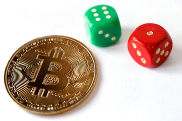 A red and green dice and a cryptocurrency coin