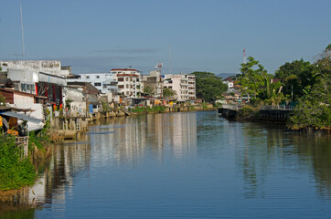 Obraz premium White building and trees with reflection in the water