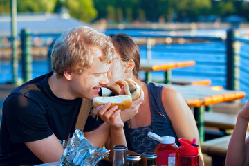 Young couple having a fun picnic by the lake