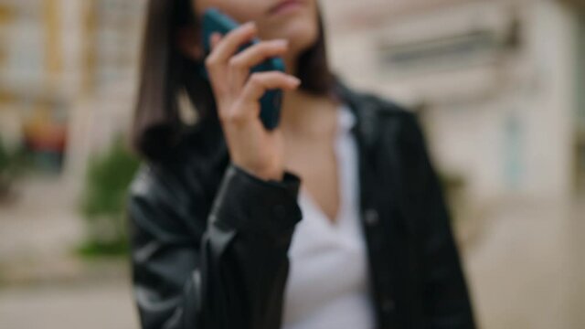 Young hispanic woman smiling confident talking on the smartphone at street
