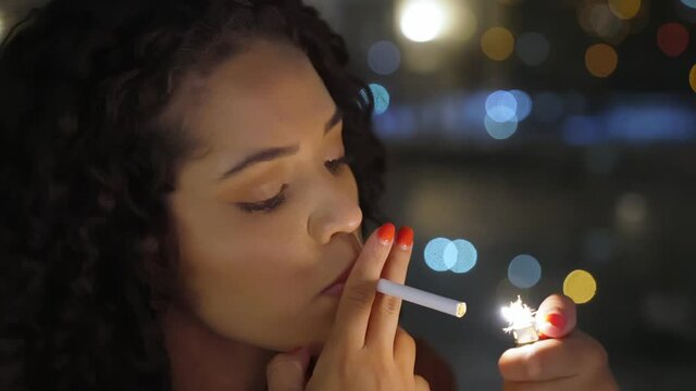 A sad Latin girl smokes late at night. Cinematic 4K