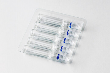 ampoules with medicine in a transparent tray on a white background