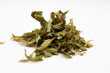 Scattered dried ivan tea on a white blurred background with an amulet