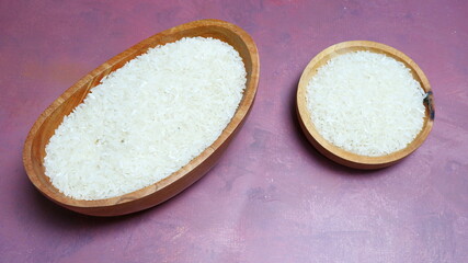 Rice in a wooden bowl with some neat and simple kitchen ornaments giving an elegant and attractive impression. food and beverage concept. rice is a symbol of prosperity.