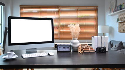 Mock up computer with white display and supplies on lack wooden table.