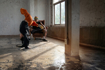 Fototapeta premium Couple dancers practice break dance in empty room, sunlight shining into the room, Tattoo on body