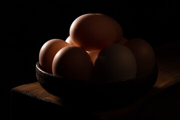chicken eggs in a pot on a black background