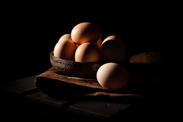 Chicken eggs in a pot on black background