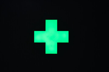 Illustration of green cross of pharmacy at Swiss railway station at City of Zürich on a rainy winter day. Photo taken December 24th, 2021, Zurich, Switzerland.