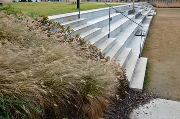concrete staircase serves as a theater bench overlooking river. cobblestone cobblestones cubes on promenade with wooden benches. you can also sit on long wide stairs lined with tropical wood. drain 