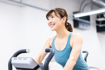 ジムでマシーントレーニングをする若い女性