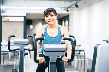 Obraz premium ジムでマシーントレーニングをする若い女性