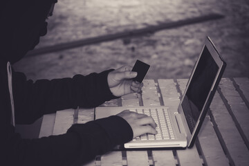 Anonymous hacker using laptop for stealing personal data from internet.