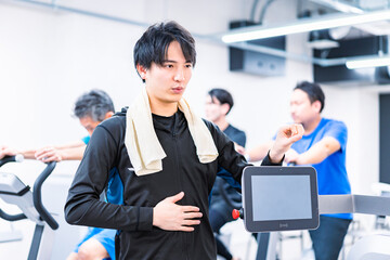 ジムでトレーナーの指導を受ける若い女性