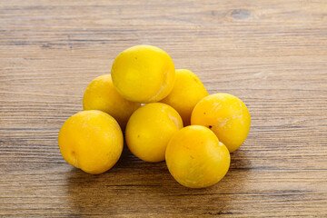 Ripe sweet yellow plum heap over background