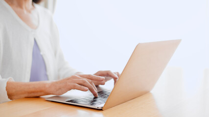 ノートパソコンを使うシニア女性