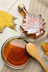 Flat lay composition with tasty maple syrup and dry leaves on light grey table