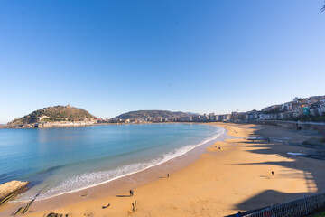 People walking on La Cocha beach in the city of San Sebastian one sunny morning, Gipuzkoa. Basque Country