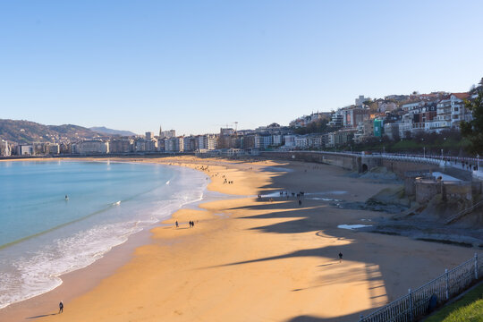 People walking on La Cocha beach in the city of San Sebastian one sunny morning, Gipuzkoa. Basque Country